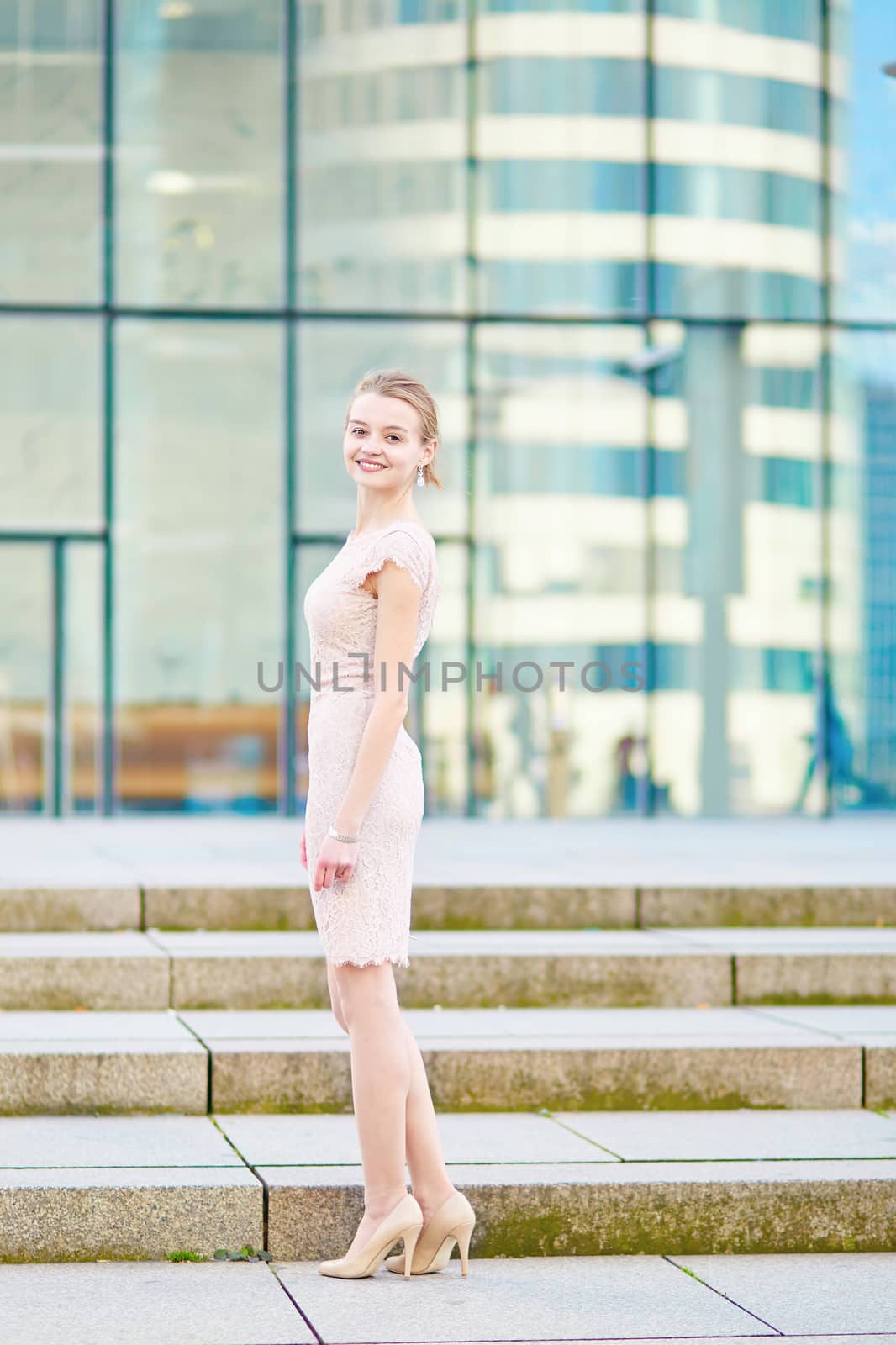Beautiful young business woman in modern glass office interior