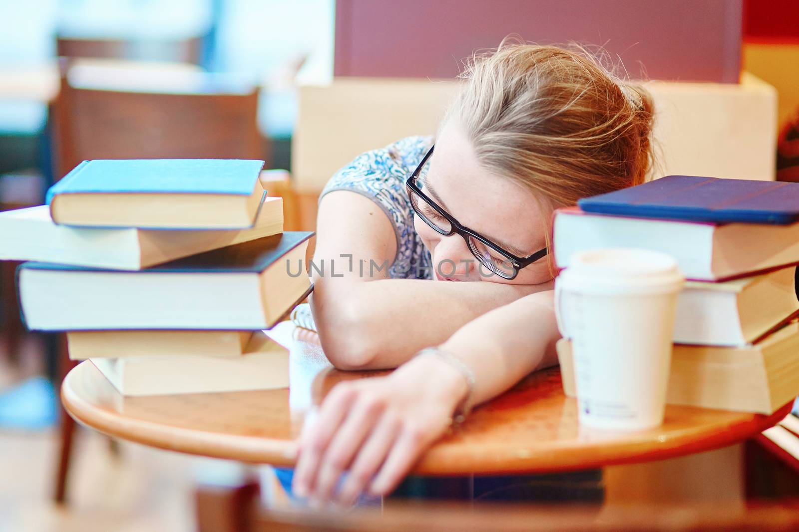 Exhausted student with books and papers, studying at home. Quarantine and closed schools and offices during coronavirus outbreak. Homeschooling, distance learning and freelance job