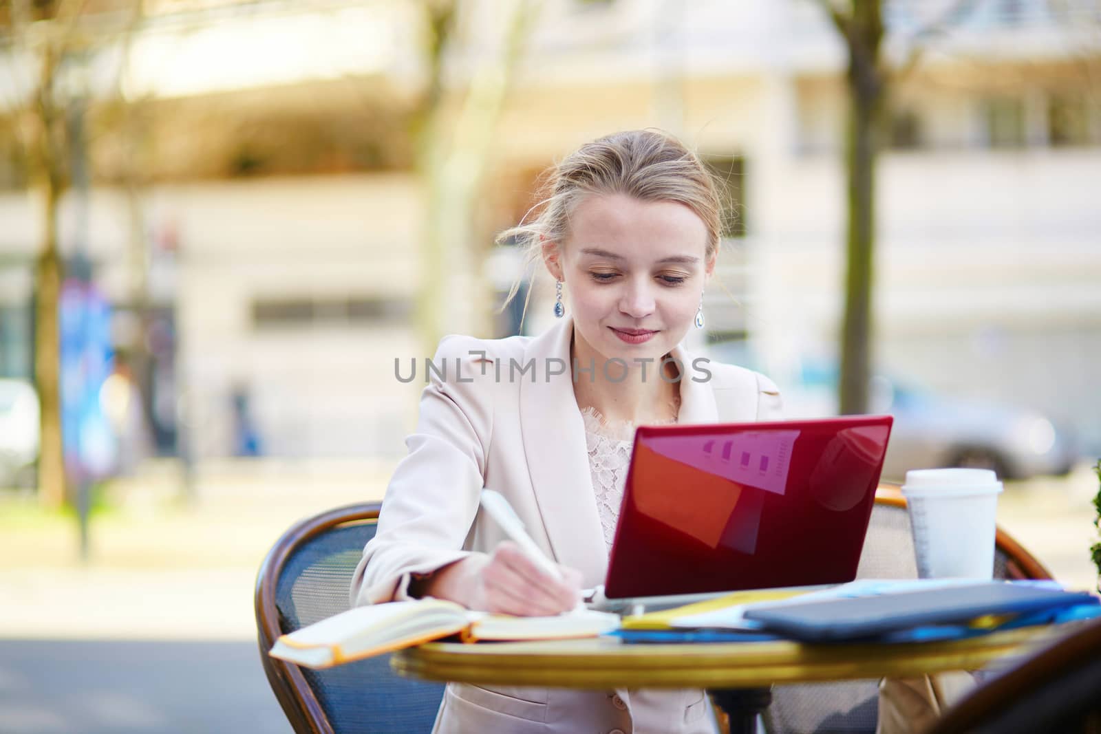 Young businesswoman on a coffee break, using her mobile laptop