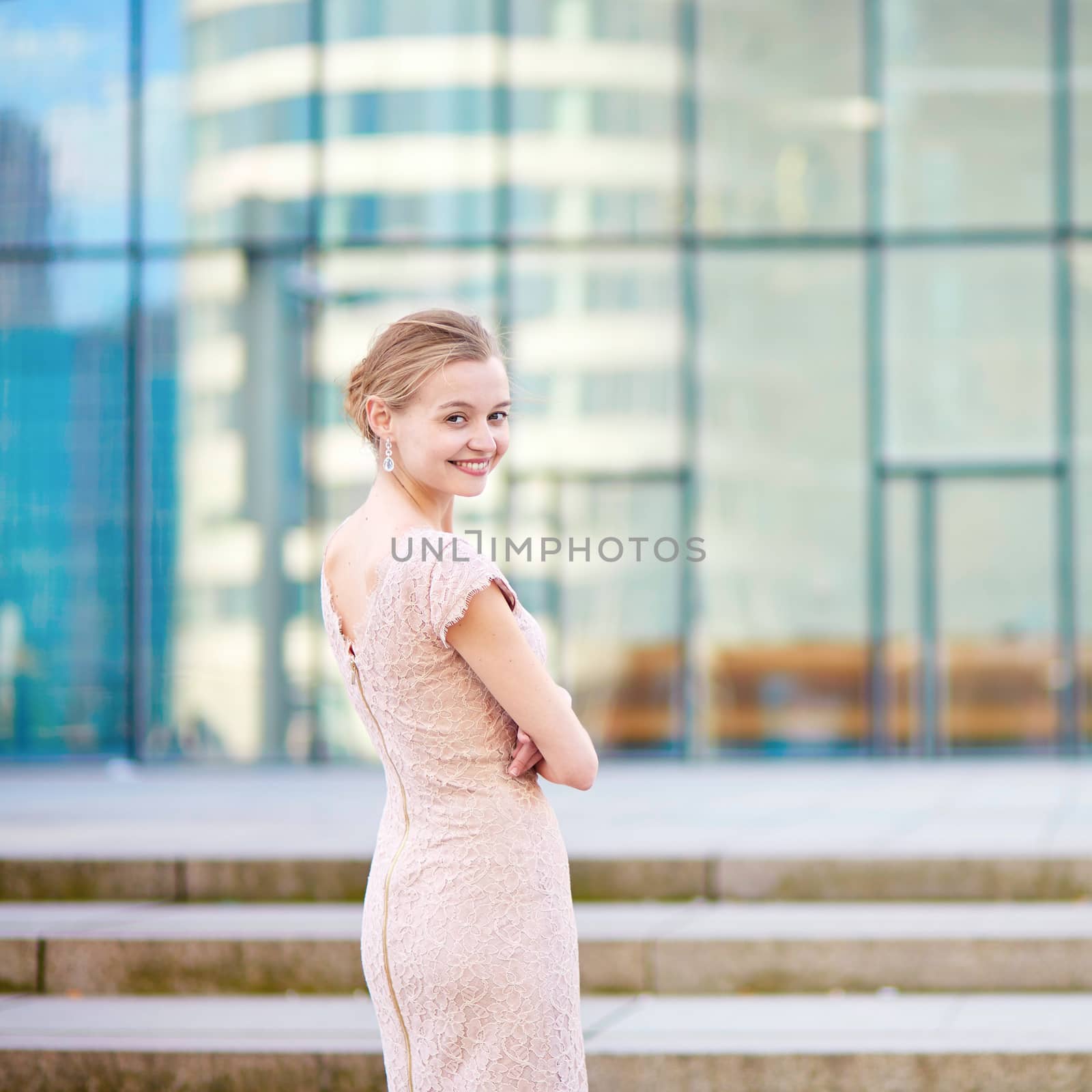 Beautiful young business woman in modern glass office interior