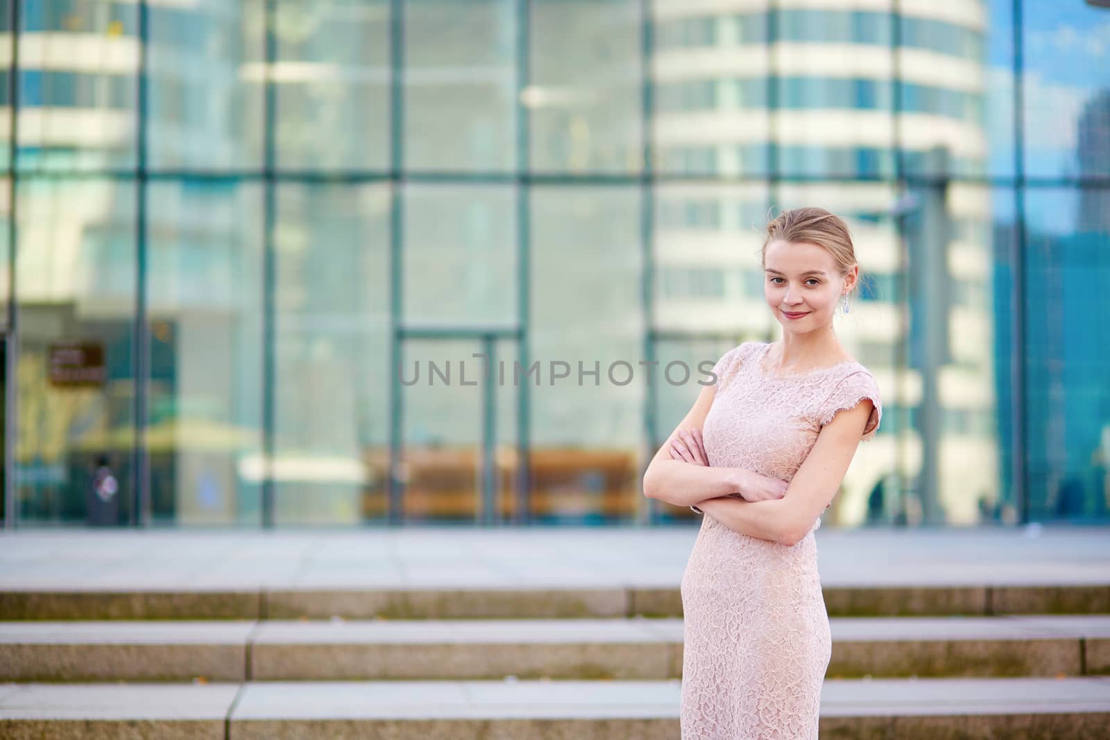 Beautiful young business woman in modern glass office interior