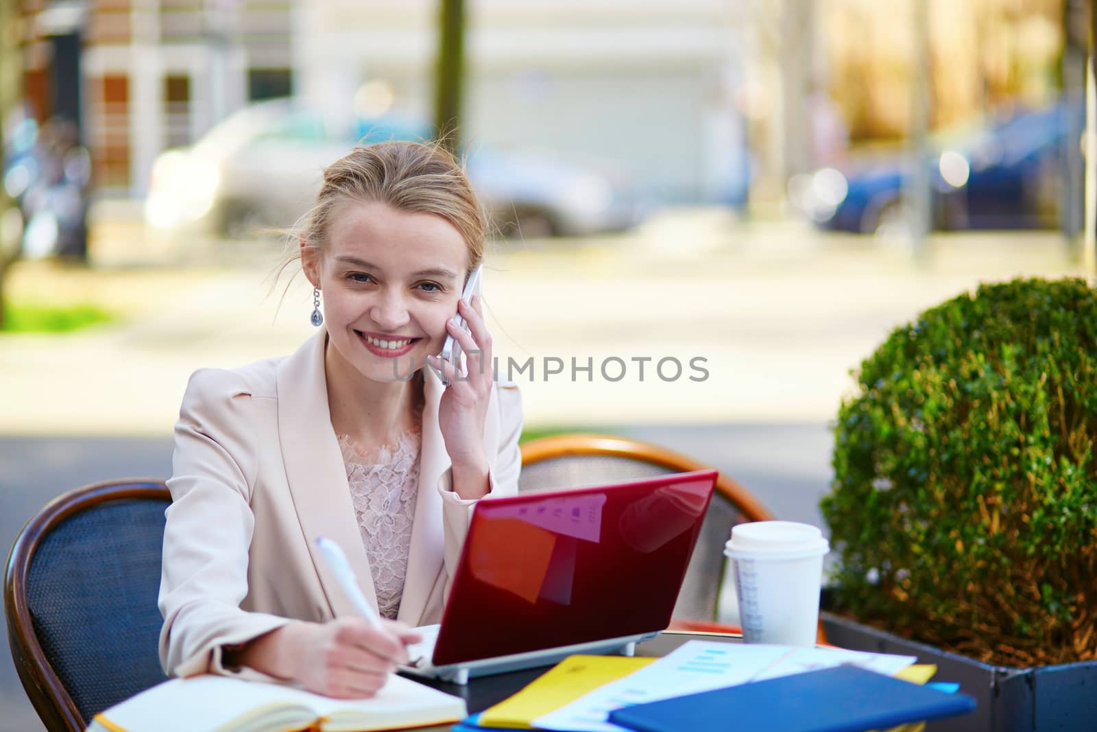Young businesswoman on a coffee break, using her mobile phone