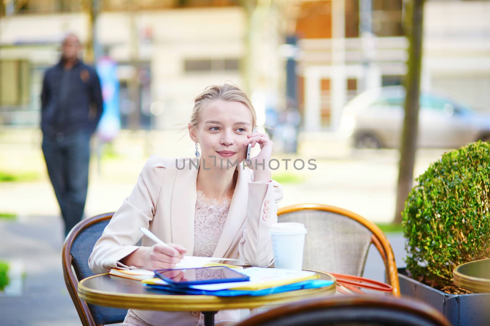Young businesswoman on a coffee break, working and speaking on the phone