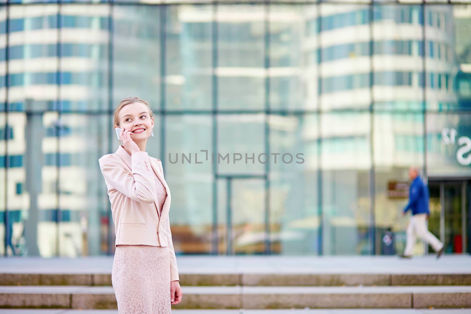 Beautiful young business woman in modern glass office interior