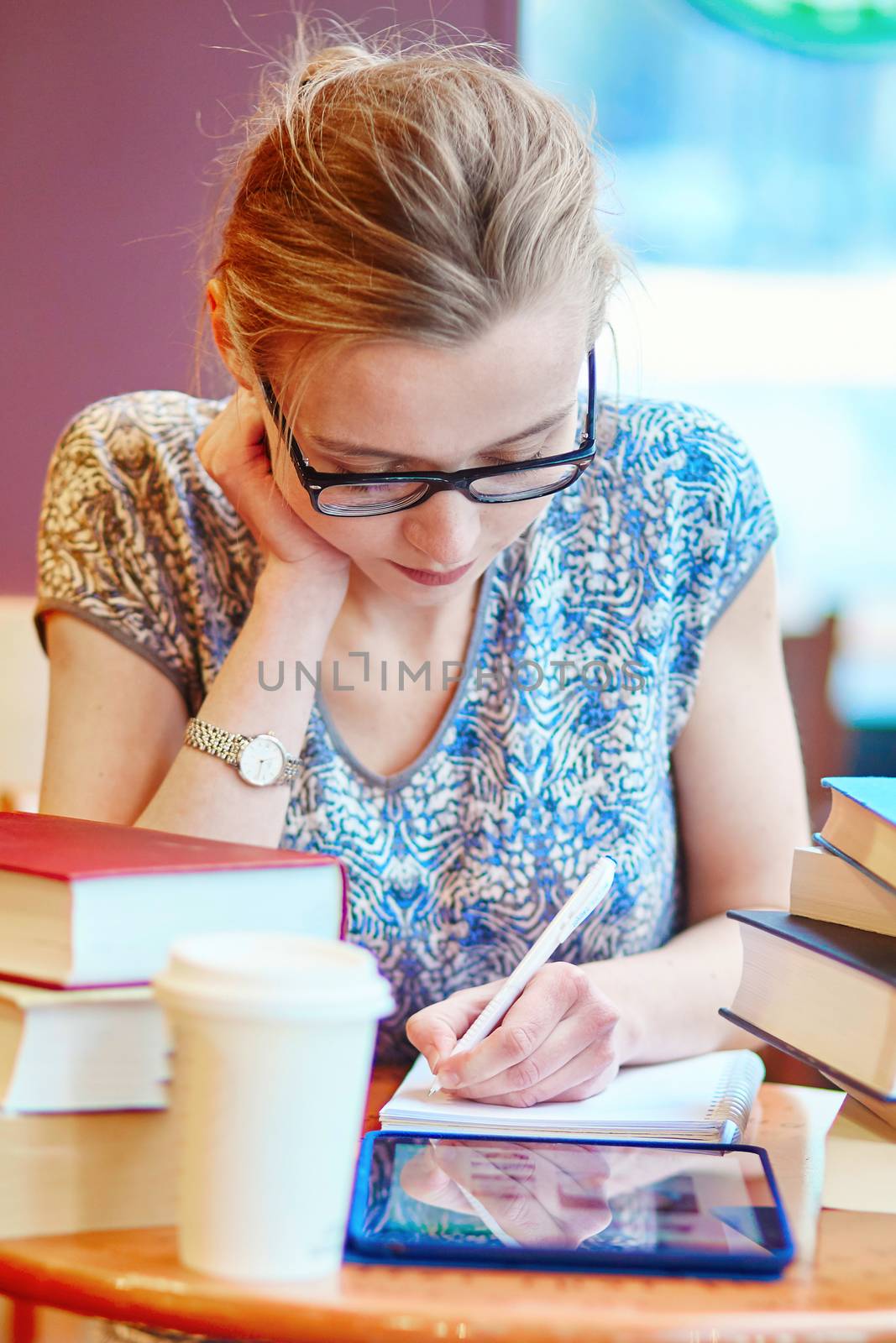 Student with tablet, books and papers, studying at home. Quarantine and closed schools and offices during coronavirus outbreak. Homeschooling, distance learning and freelance job