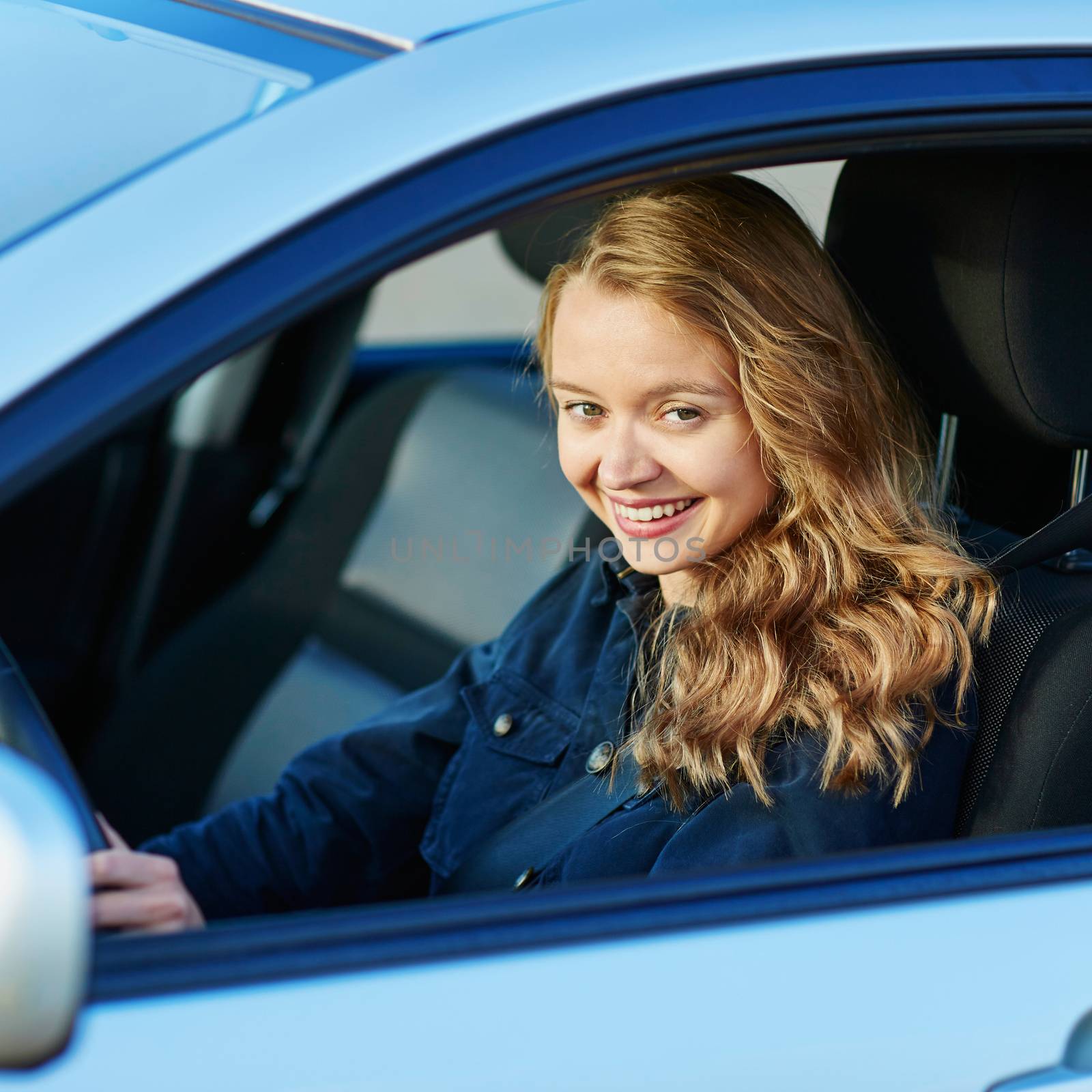 Beautiful young confident woman driving a car