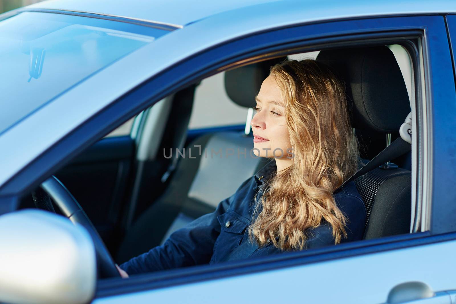 Beautiful young confident woman driving a car