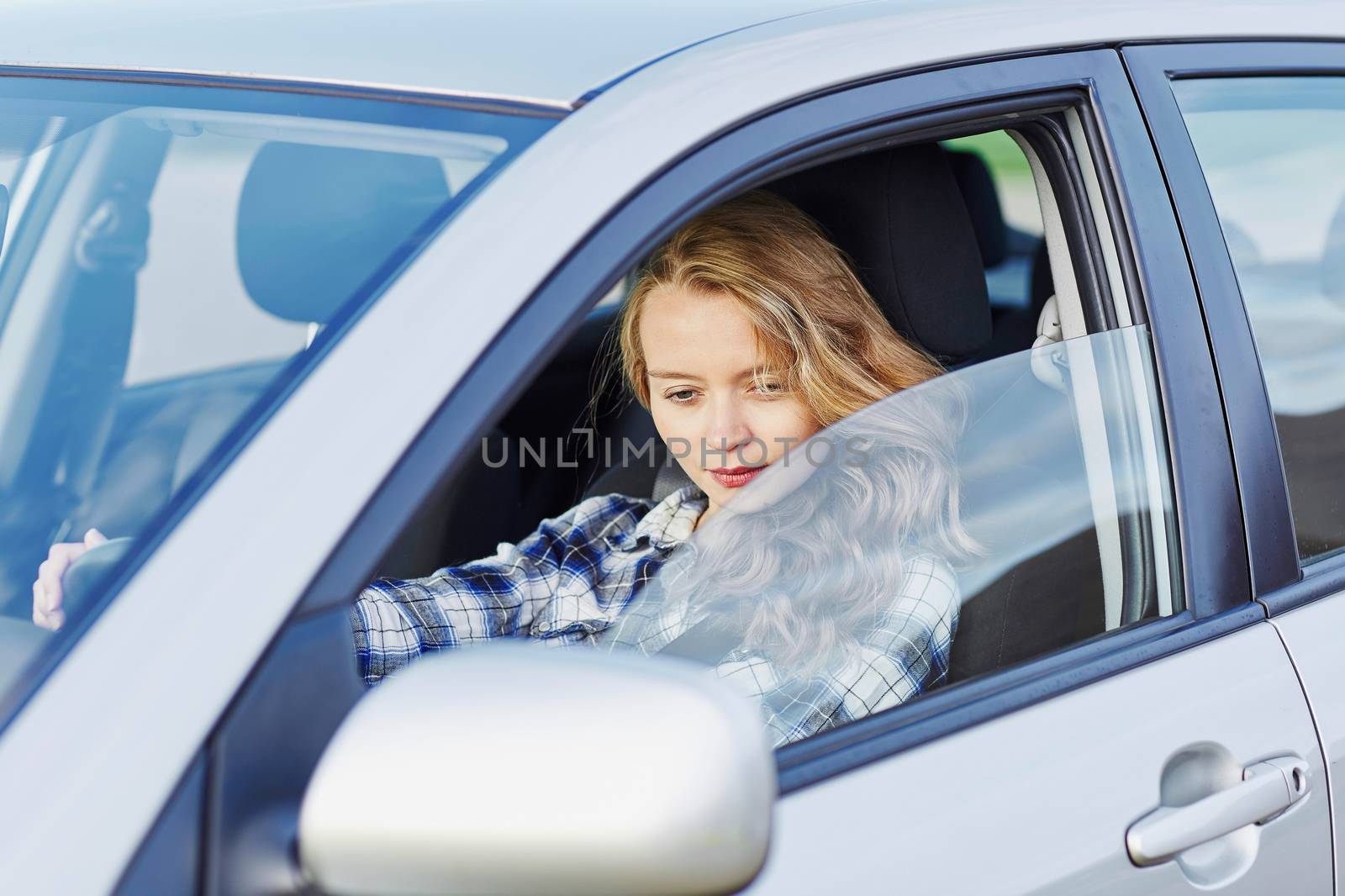Beautiful young confident woman driving a car