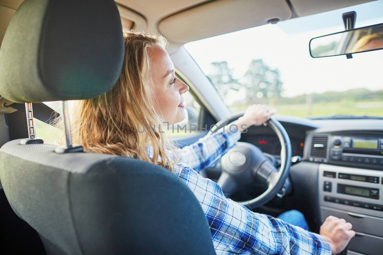 Beautiful young confident woman driving a car