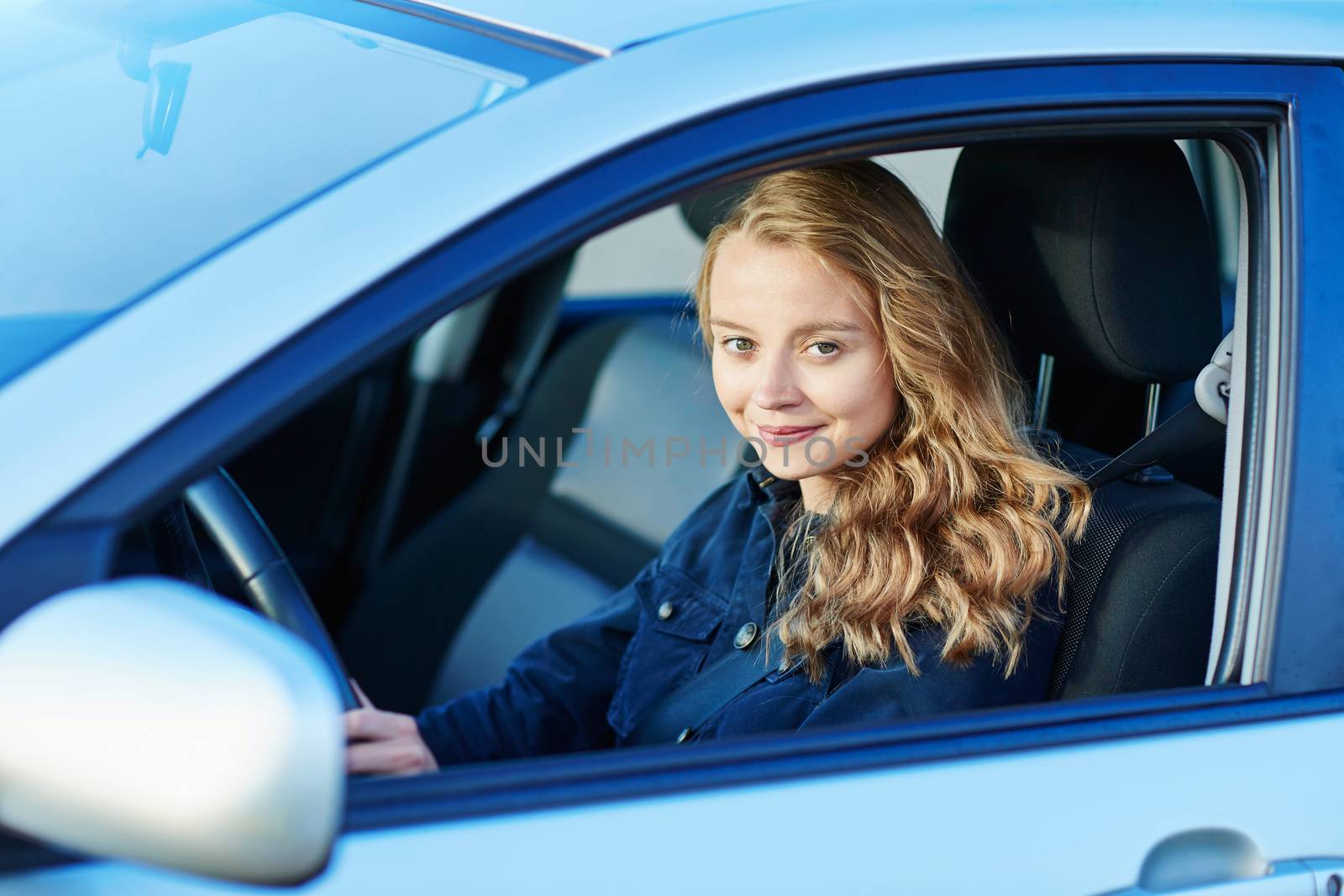Beautiful young confident woman driving a car