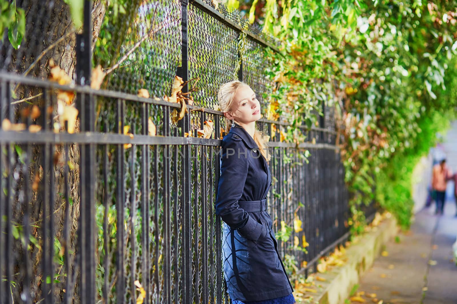 Beautiful young woman on a street of Paris on a sunny fall or spring day