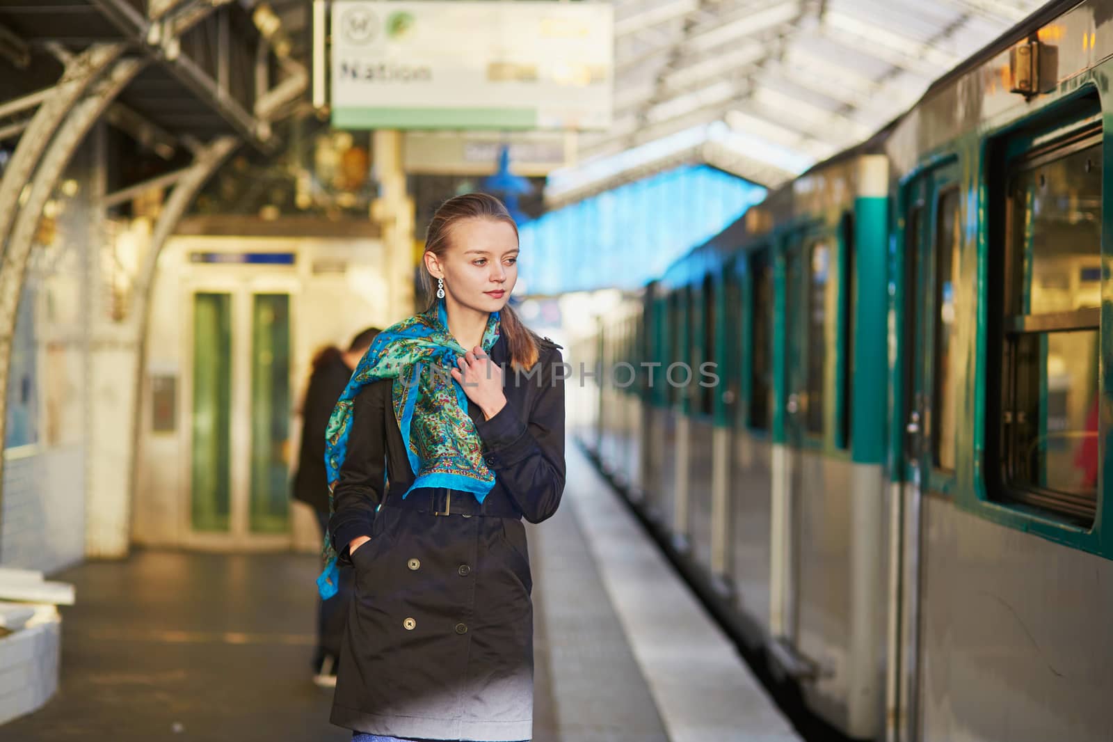 Beautiful young woman waiting for a train on the platform of Parisian underground