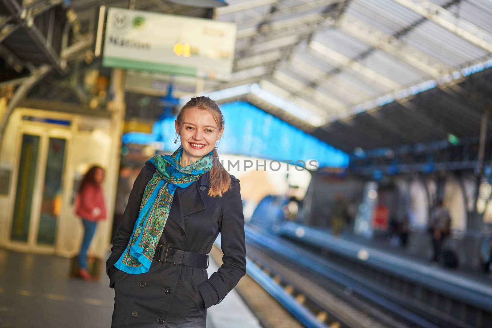 Beautiful young woman waiting for a train on the platform of Parisian underground