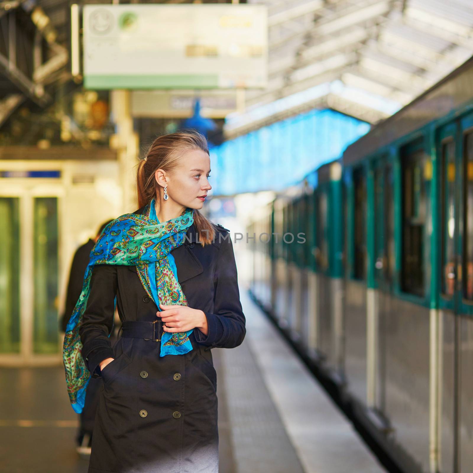 Young woman waiting for a train on the platform of Parisian underground by jaspe