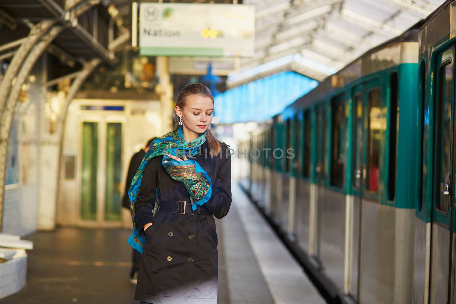 Beautiful young woman waiting for a train on the platform of Parisian underground