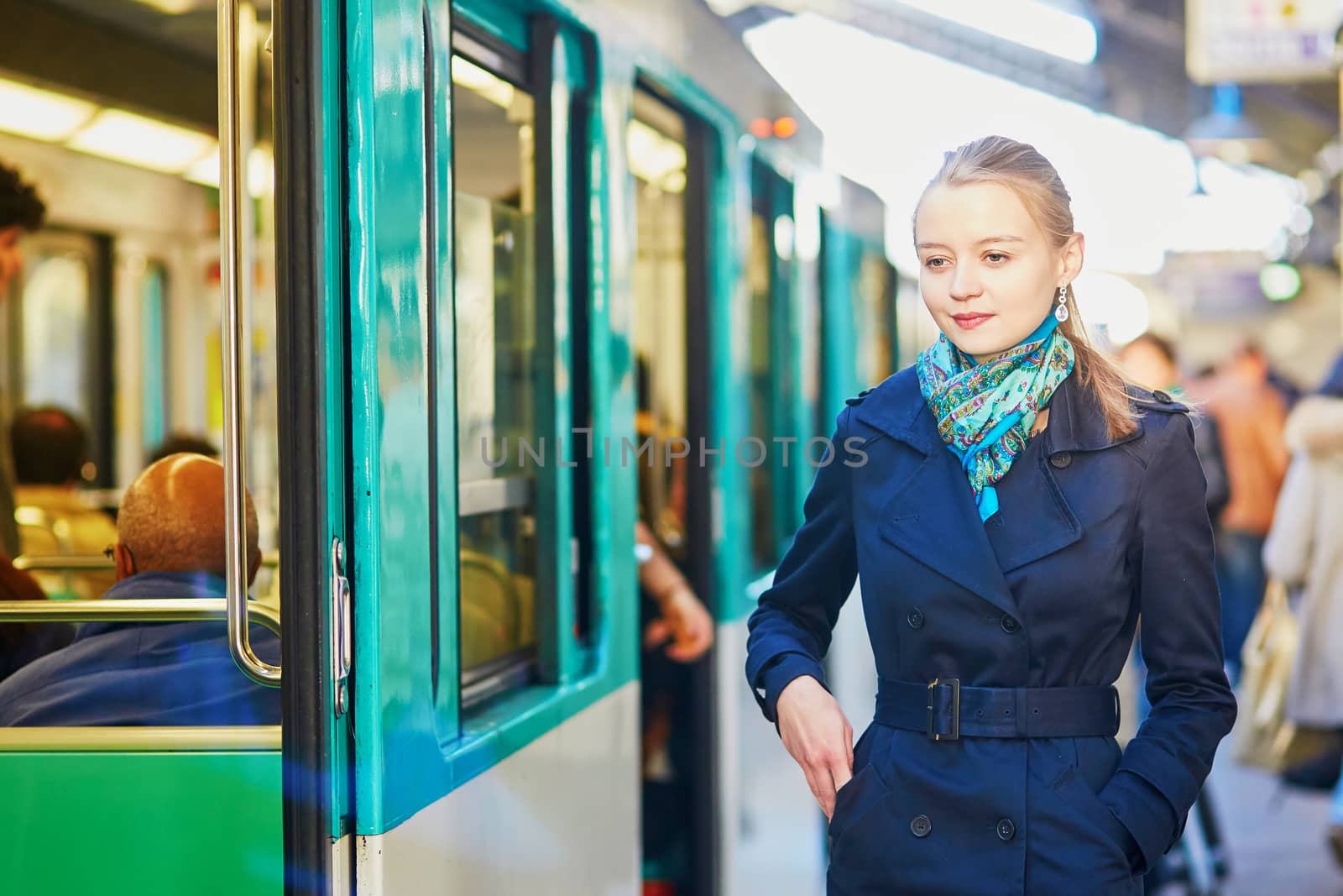 Beautiful young woman waiting for a train on the platform of Parisian underground