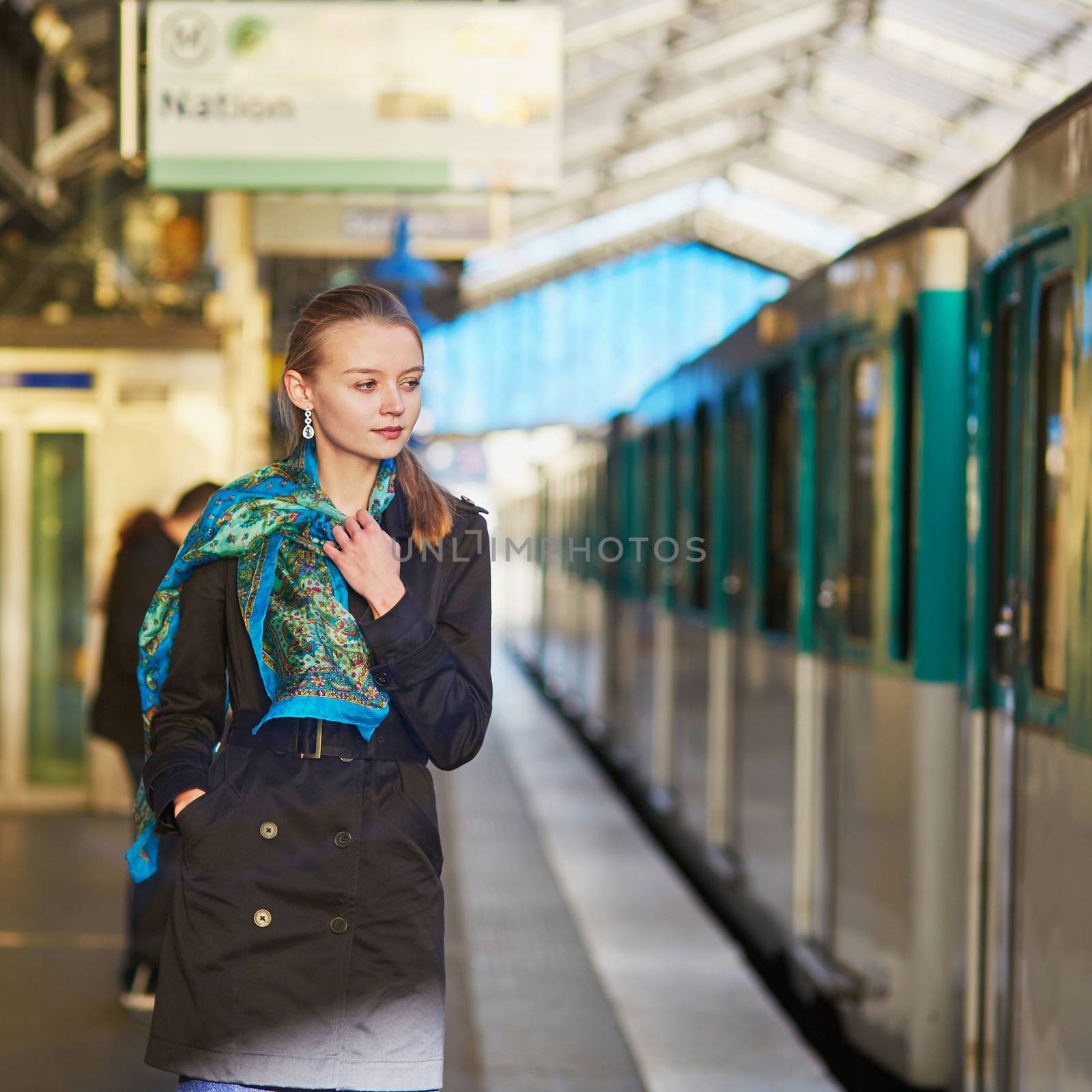 Beautiful young woman waiting for a train on the platform of Parisian underground