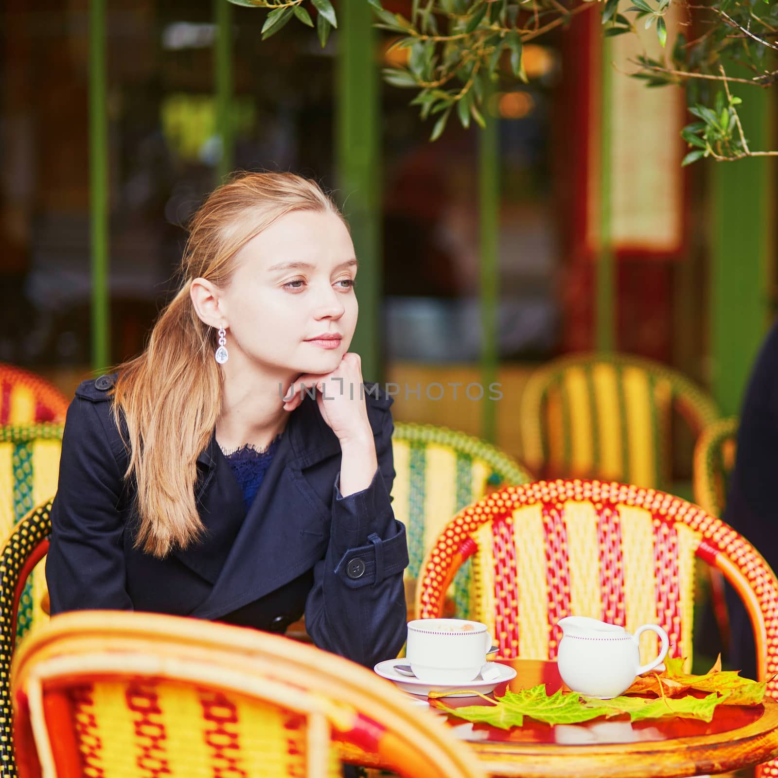Woman drinking coffee and eating delicious fresh croissant in Parisian outdoor cafe by jaspe