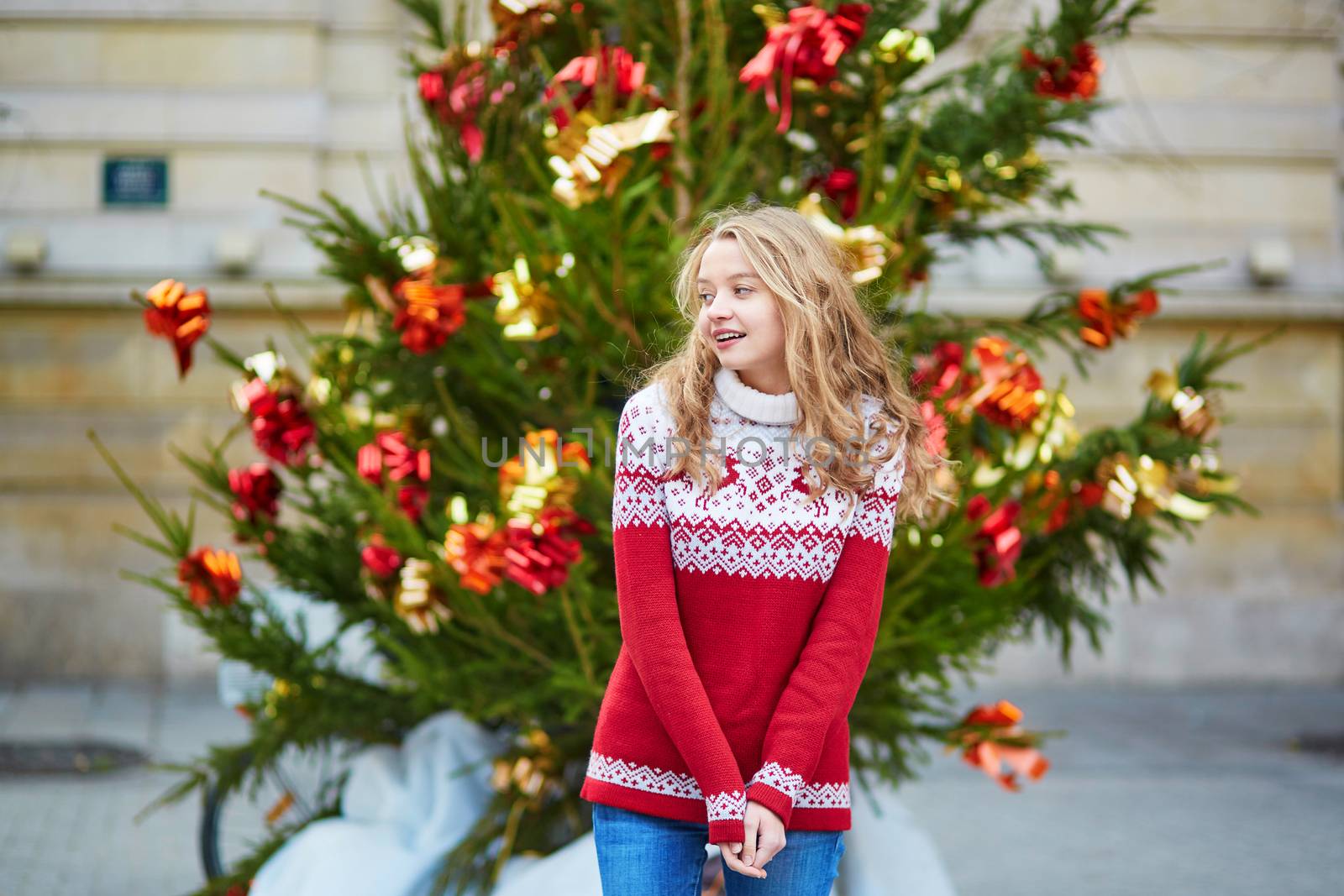 Girl with a brightly decorated Christmas tree in Paris
