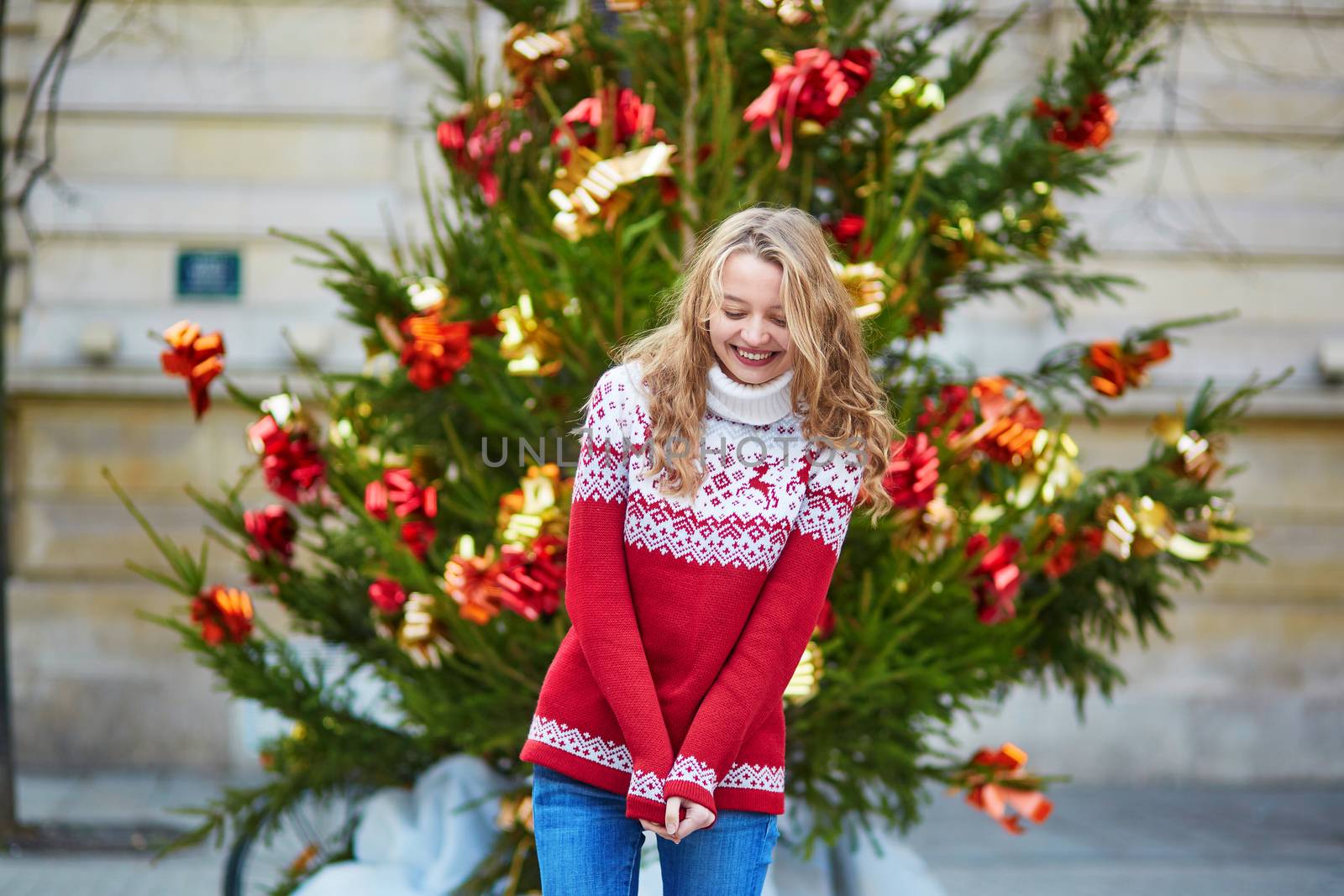 Girl with a brightly decorated Christmas tree in Paris