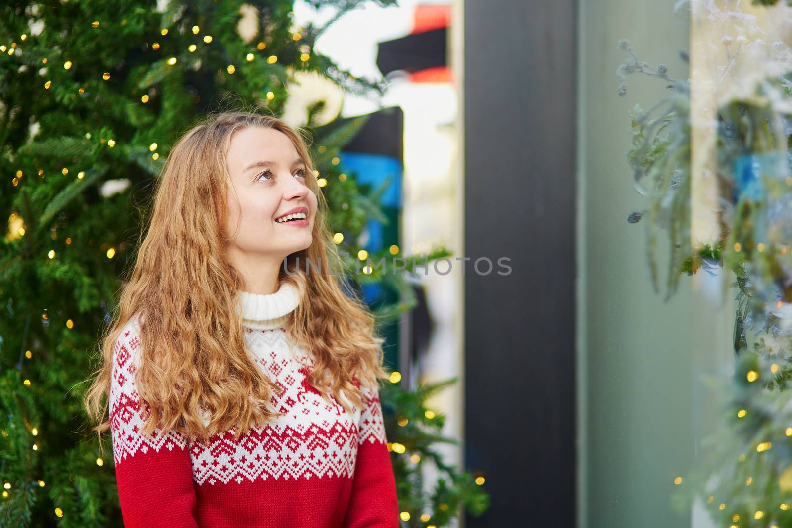 Young girl looking at Parisian shop-windows decorated for Christmas