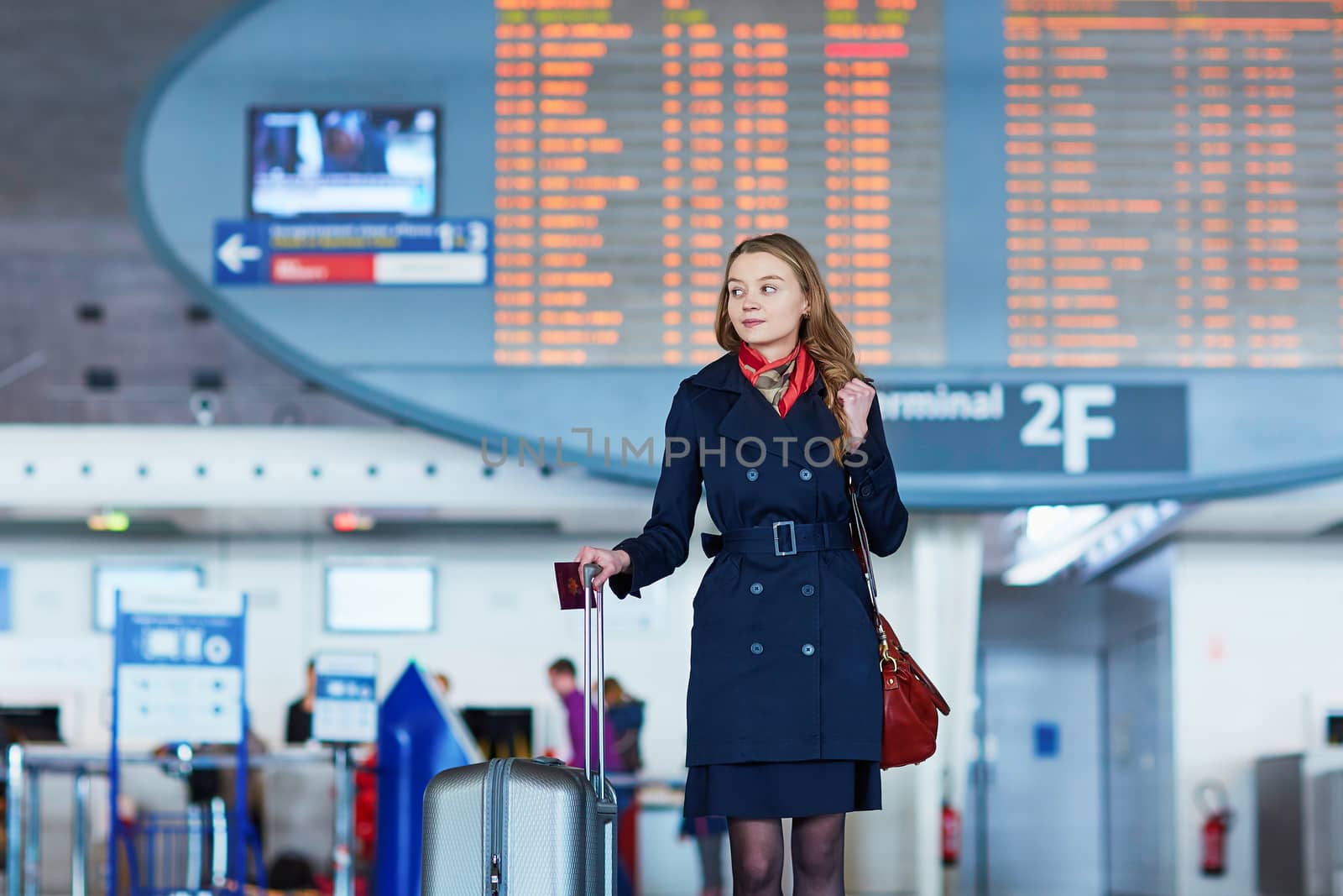 Young woman in international airport near the flight information board