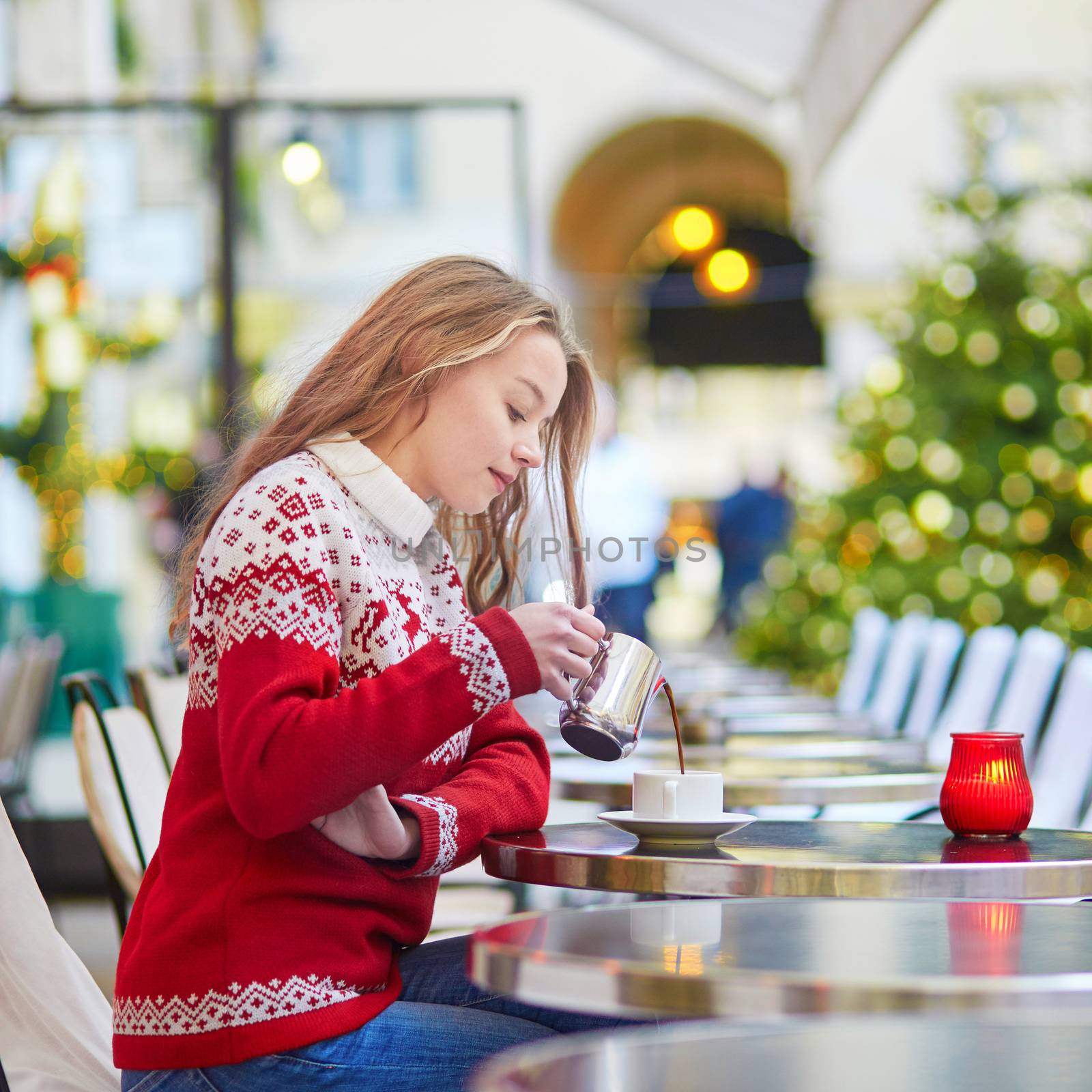 Woman drinking hot chocolate in a cozy outdoor Parisian cafe by jaspe