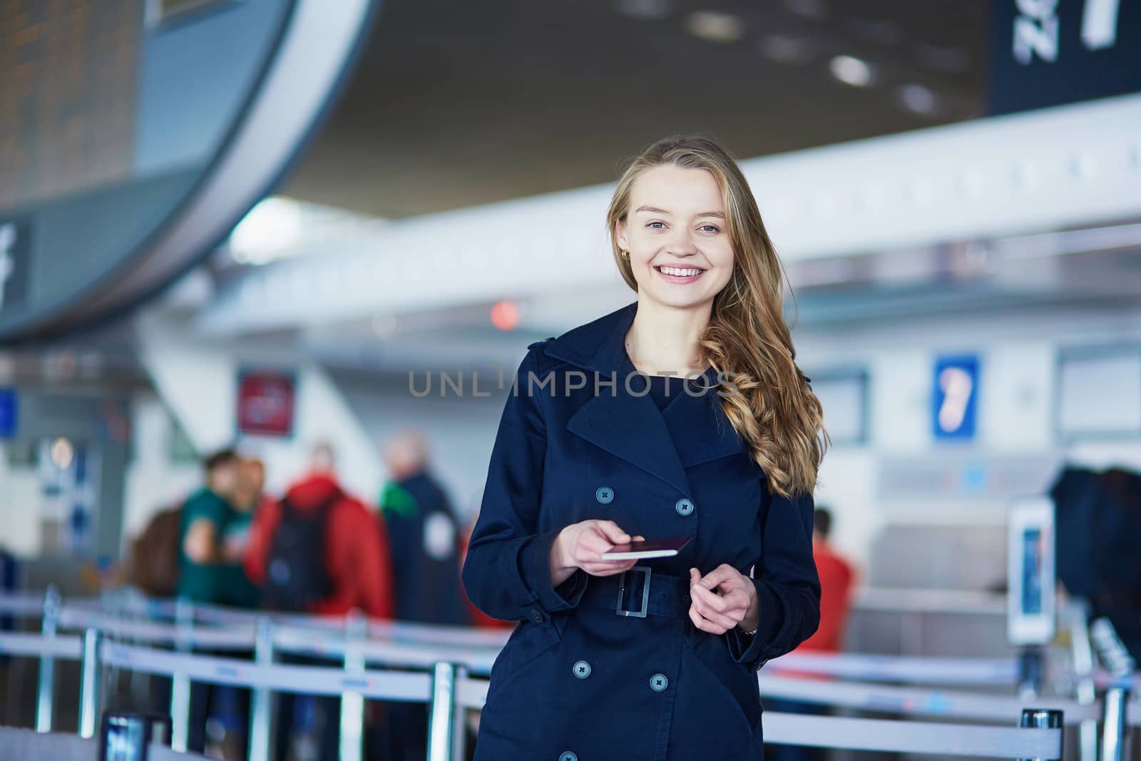 Young woman in international airport, giving her passport to an officer