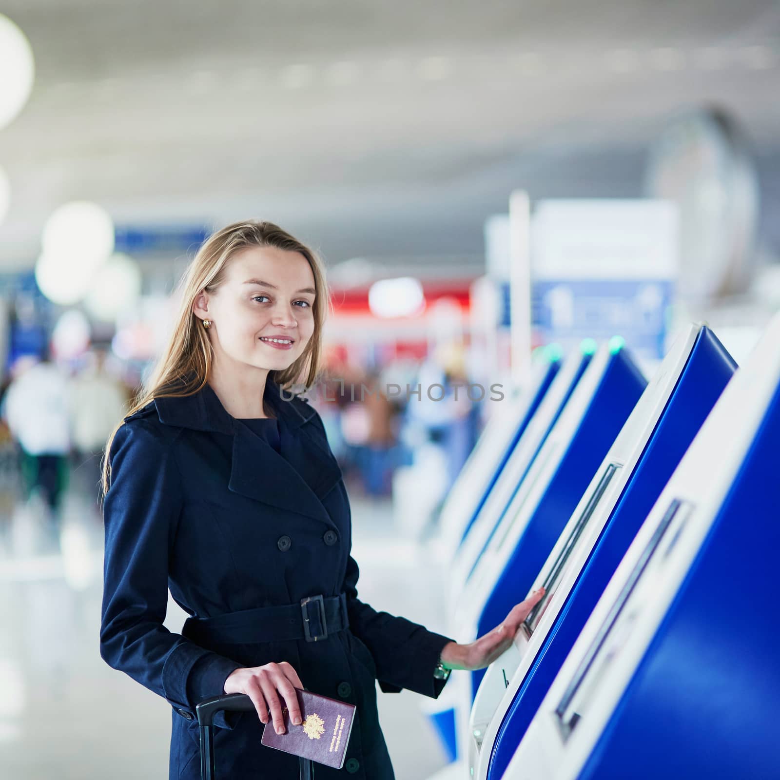 Young woman in international airport doing self check-in