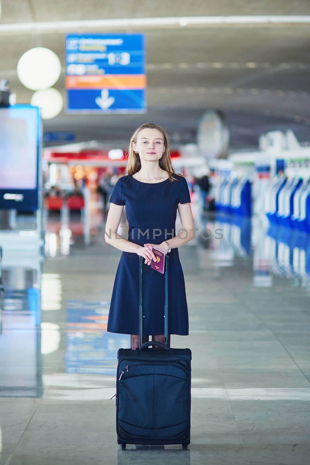 Beautiful female passenger or flight attendant in international airport with hand luggage