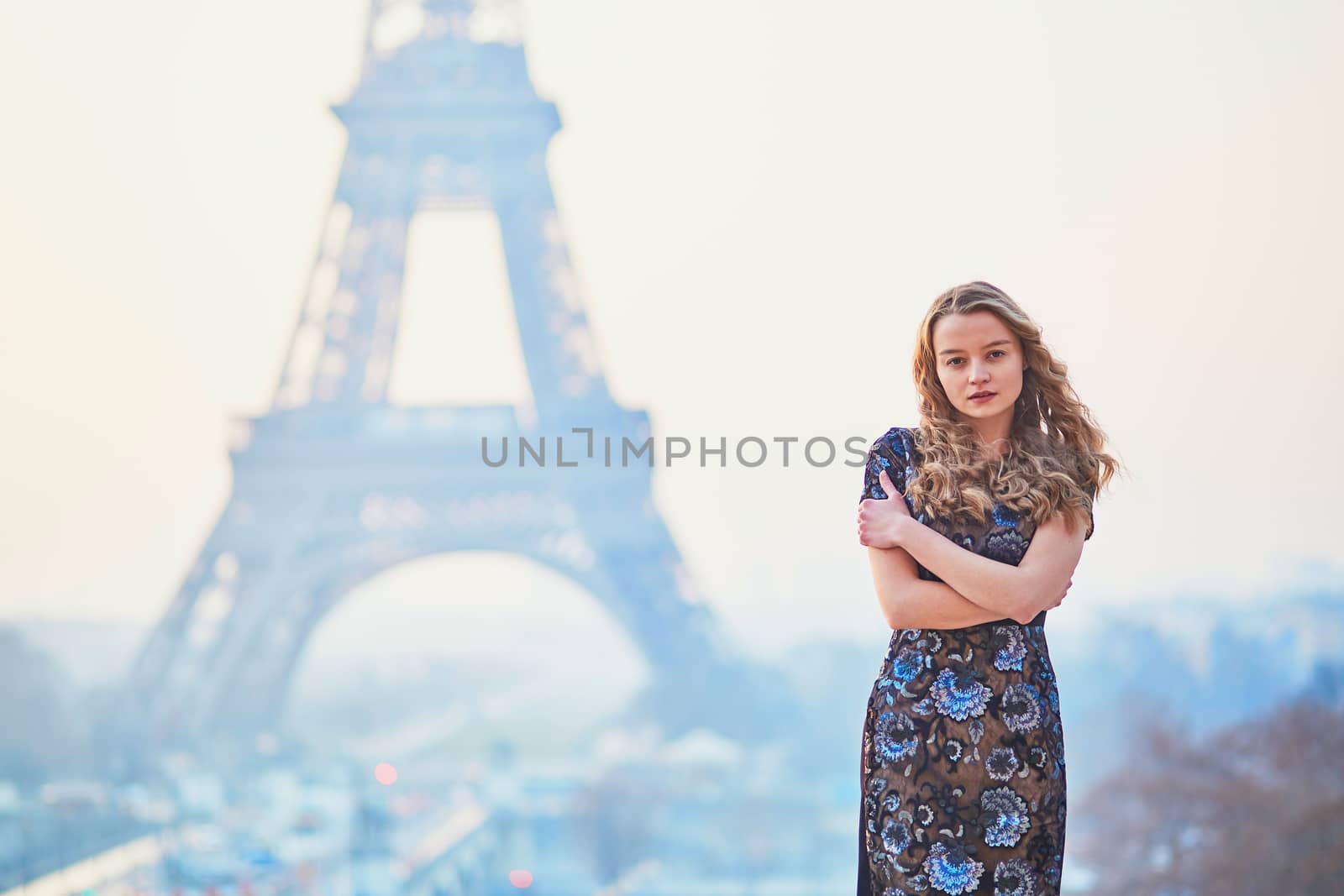 Beautiful elegant Parisian woman near the Eiffel tower at early morning