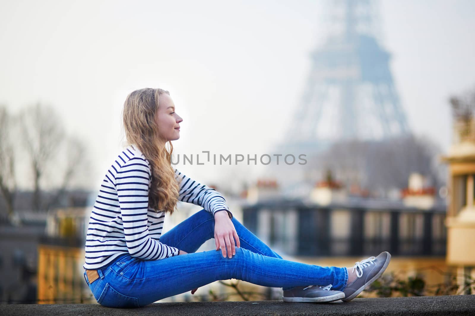 Beautiful young girl outdoors near the Eiffel tower, in Paris