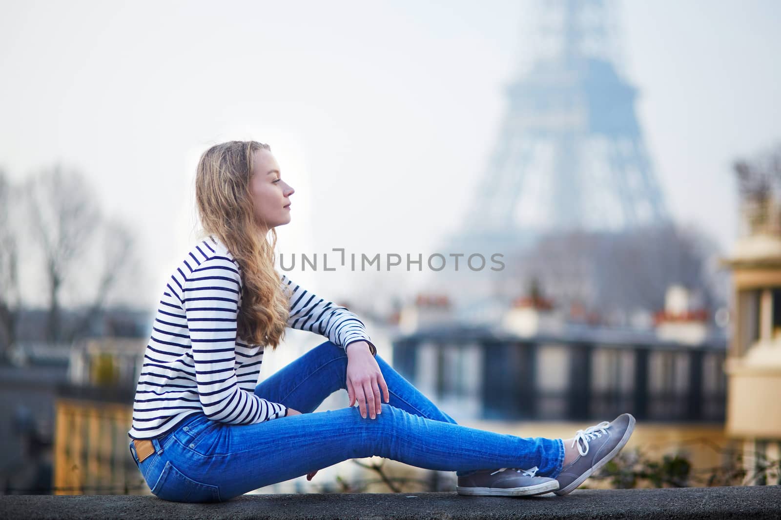 Beautiful young girl outdoors near the Eiffel tower in Paris, France