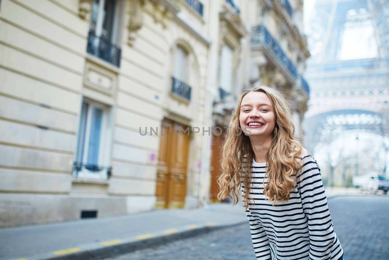 Beautiful young girl outdoors near the Eiffel tower, in Paris