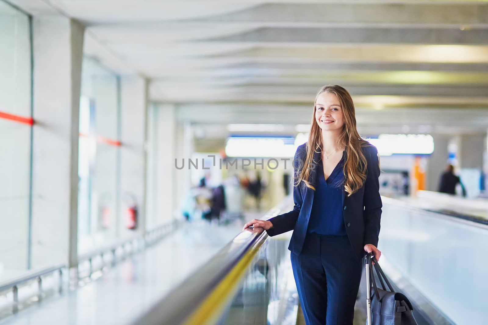 Young woman in international airport on travelator