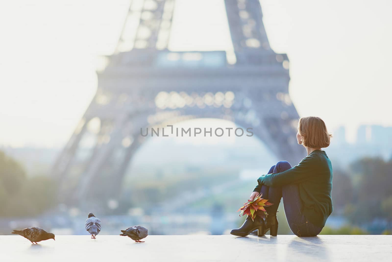 Beautiful young girl in Paris near the Eiffel tower at morning