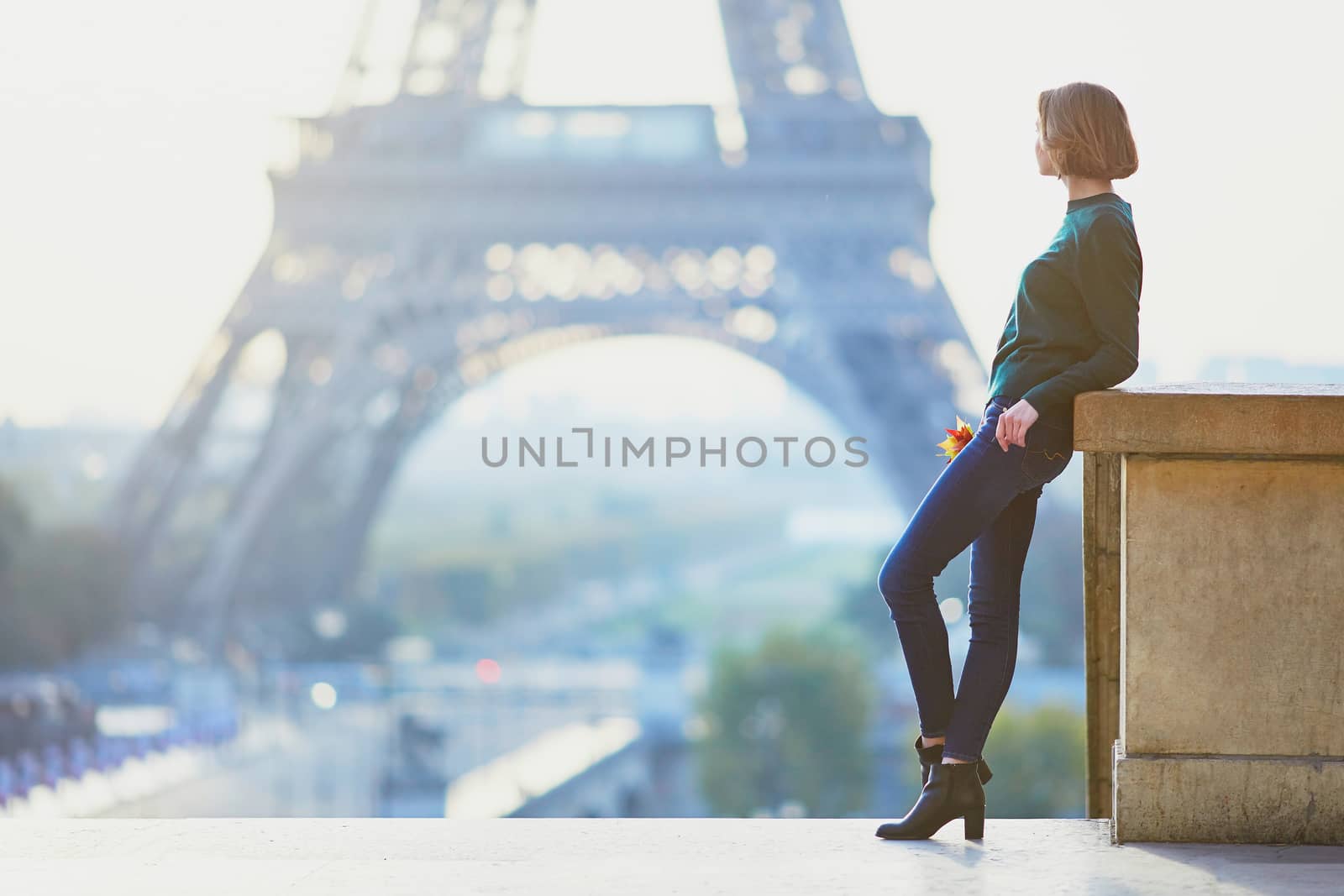 Beautiful young girl in Paris near the Eiffel tower at morning