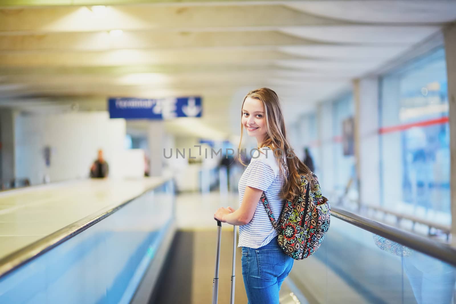 Young woman in international airport on travelator