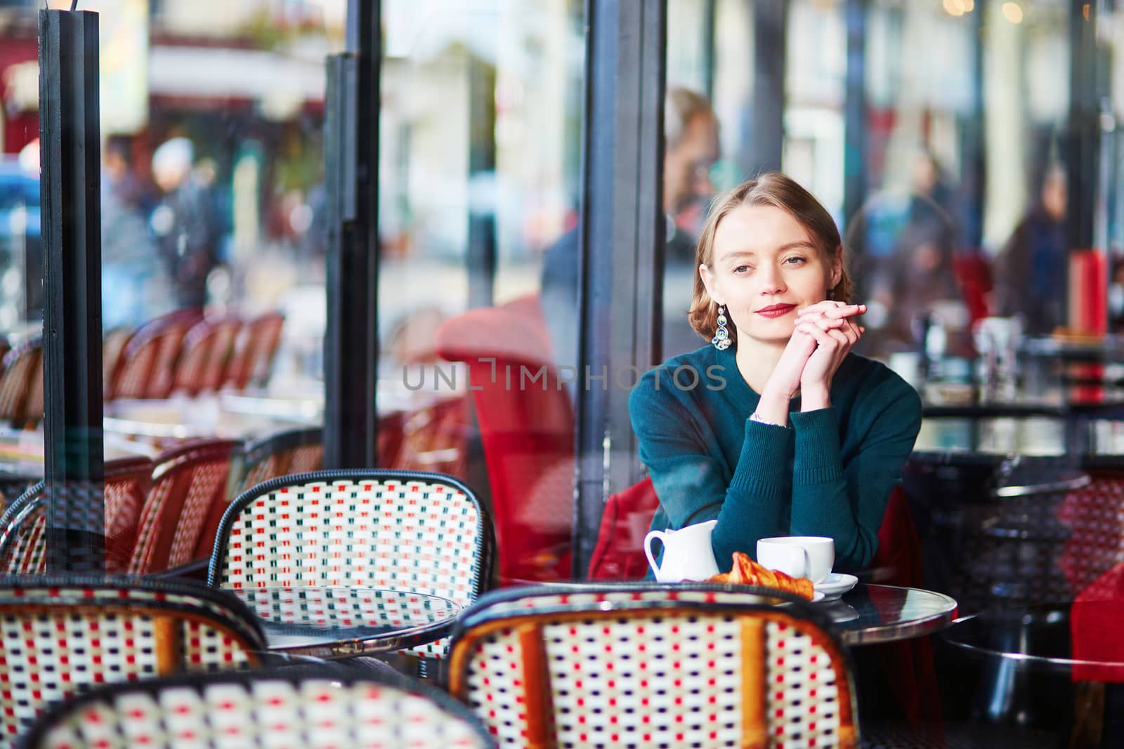 Young elegant woman drinking coffee in traditional cafe in Paris, France