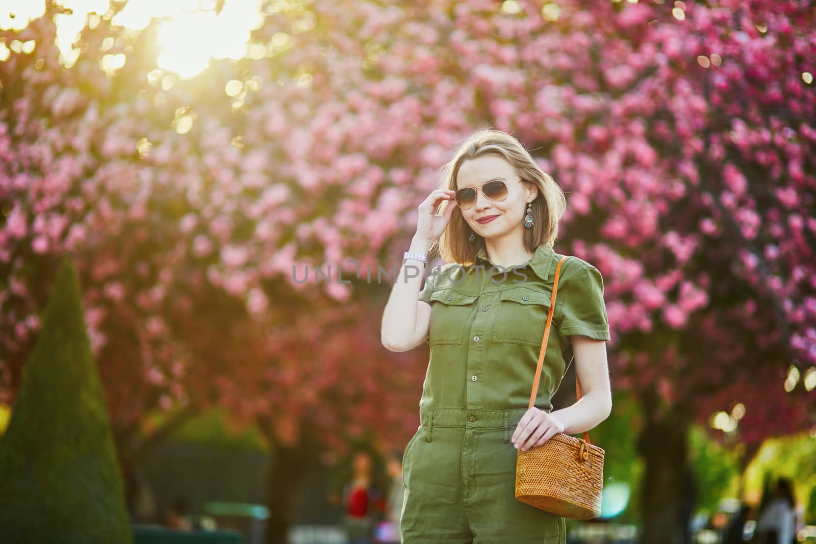 Beautiful French woman walking in Paris on a spring day at cherry blossom season