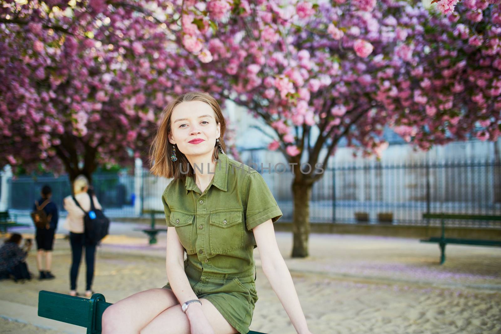 Beautiful French woman walking in Paris on a spring day at cherry blossom season
