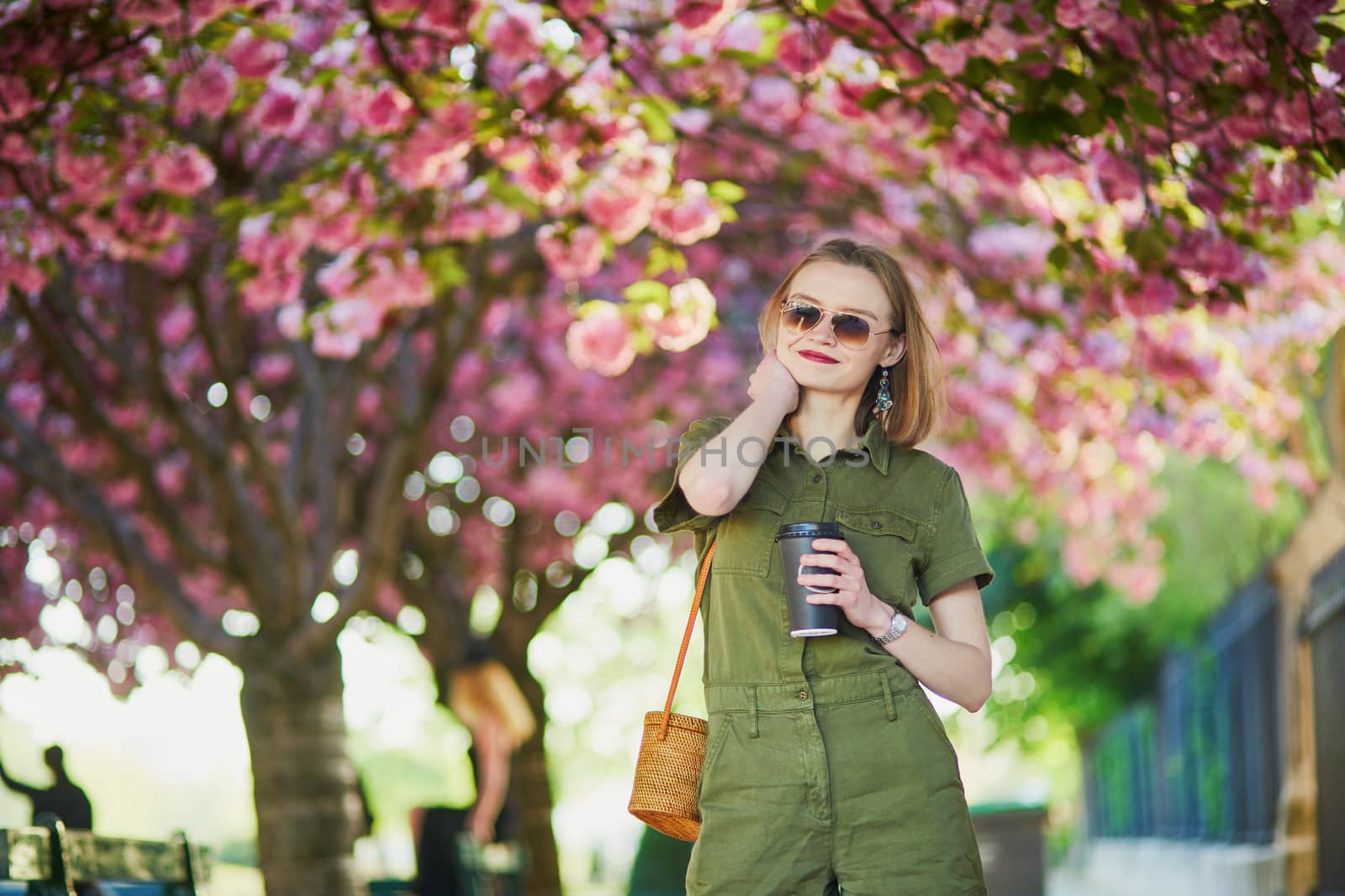 Beautiful French woman walking in Paris on a spring day at cherry blossom season