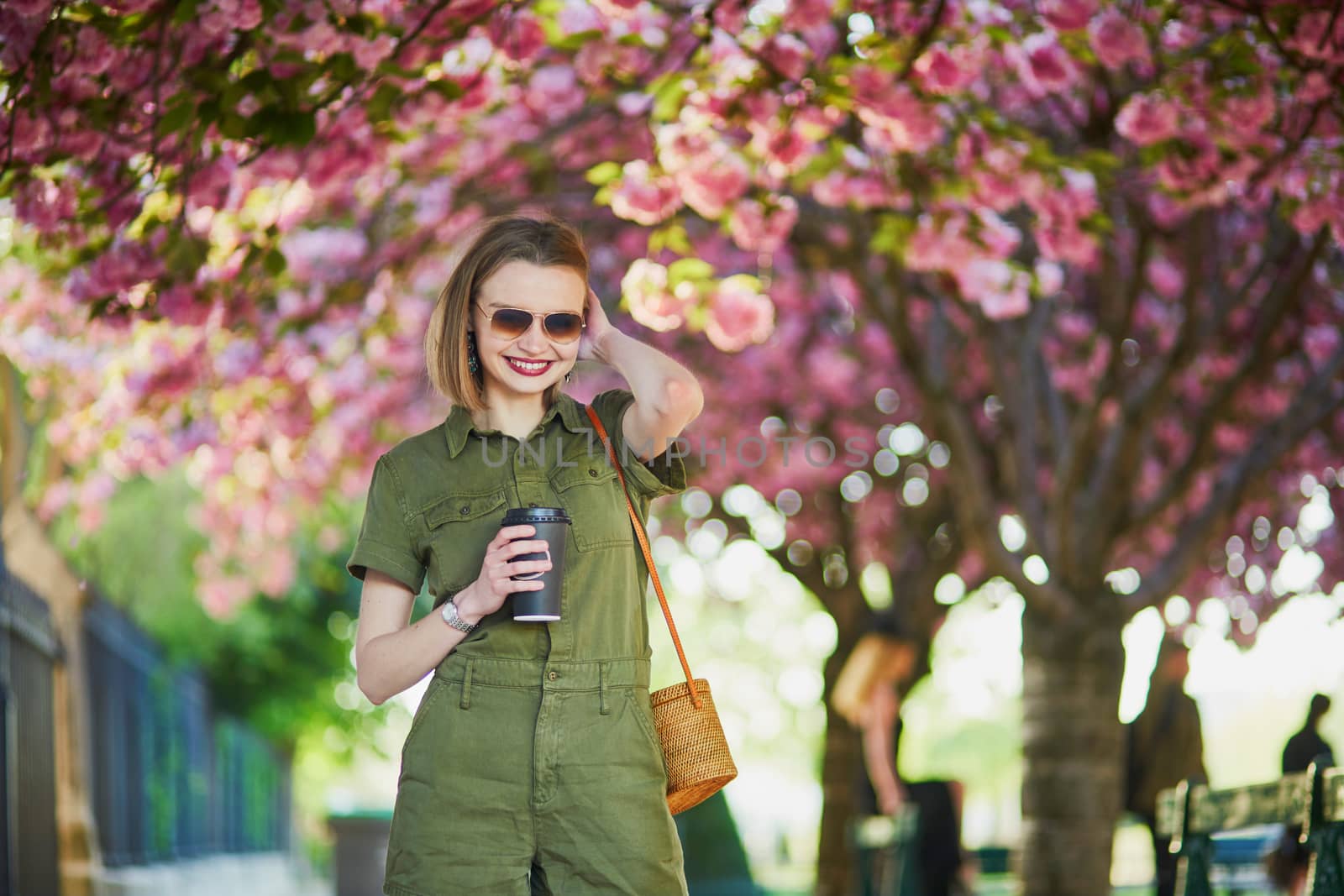 Beautiful French woman walking in Paris on a spring day at cherry blossom season