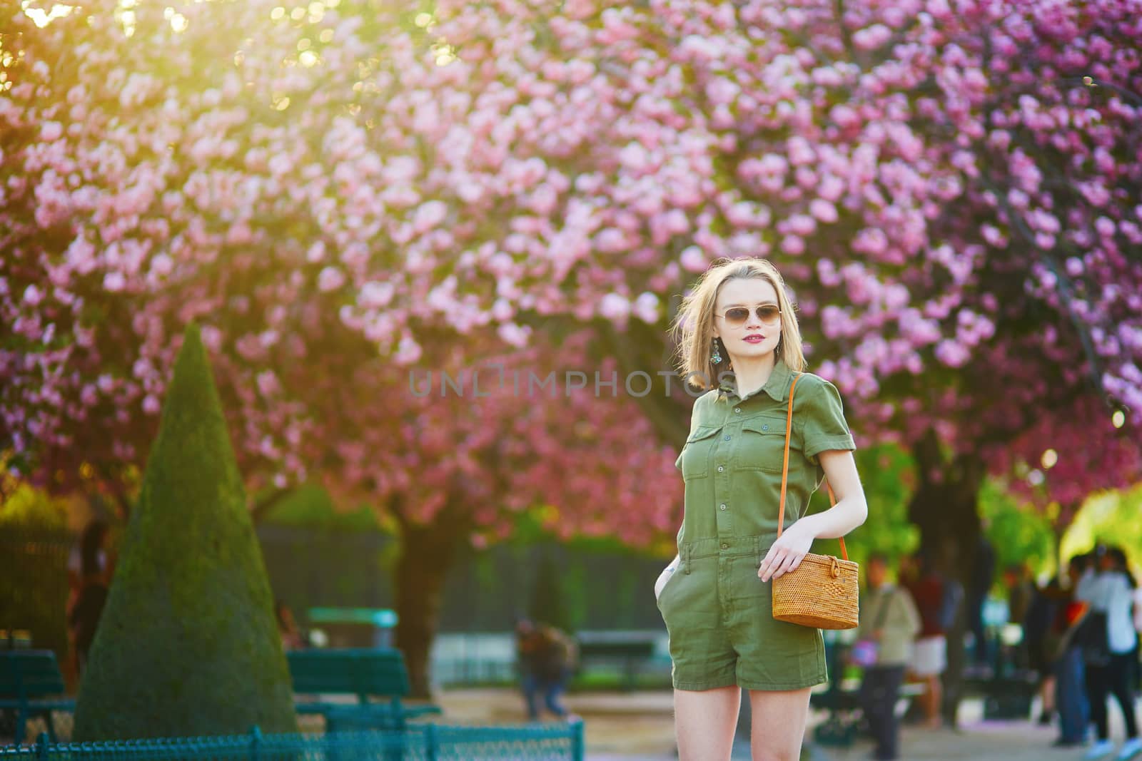 Beautiful French woman walking in Paris on a spring day at cherry blossom season