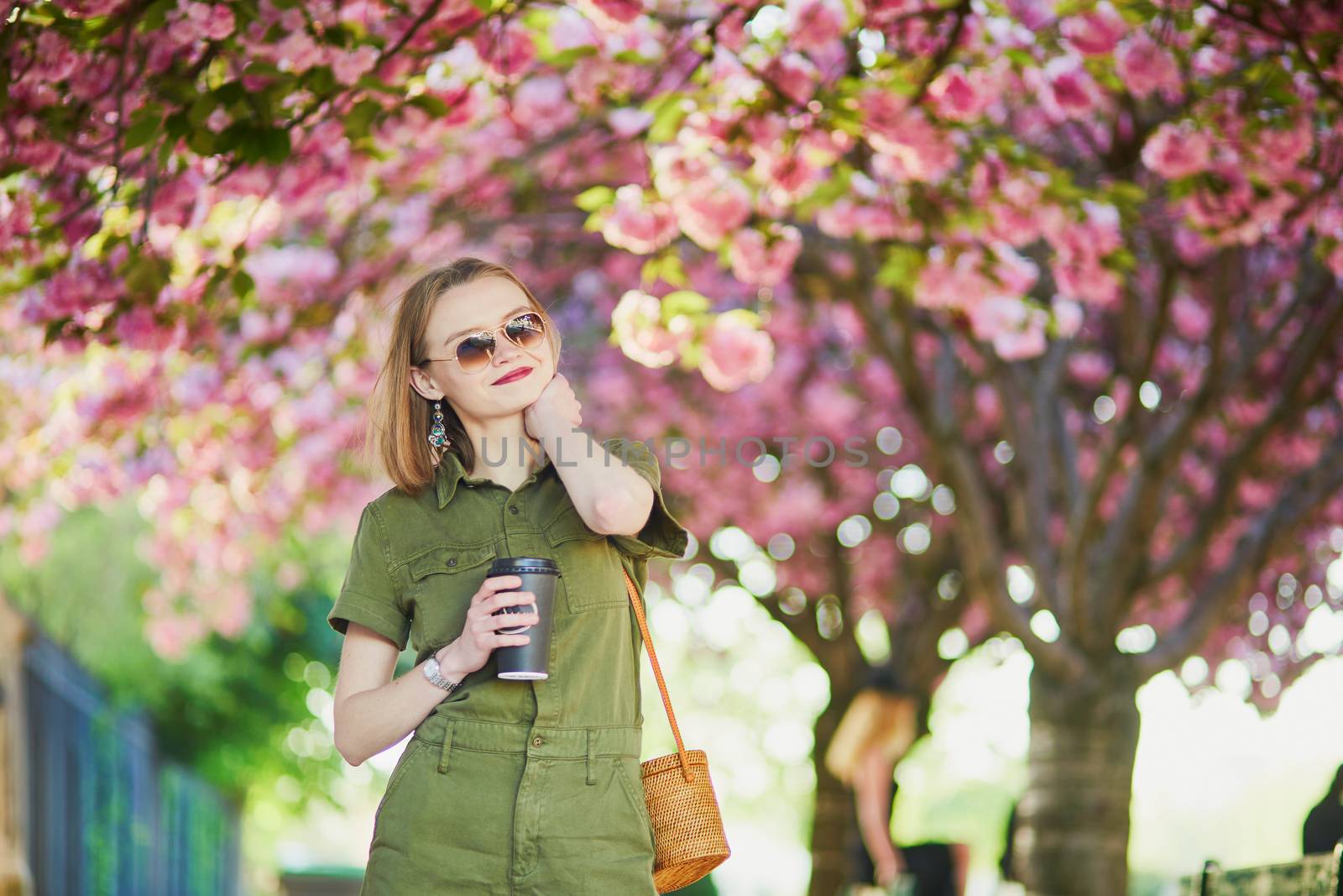 Beautiful French woman walking in Paris on a spring day at cherry blossom season