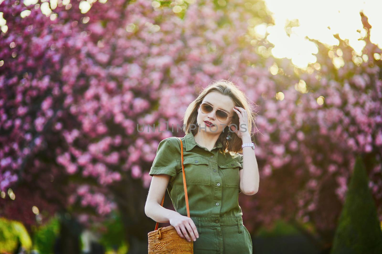 Beautiful French woman walking in Paris on a spring day at cherry blossom season