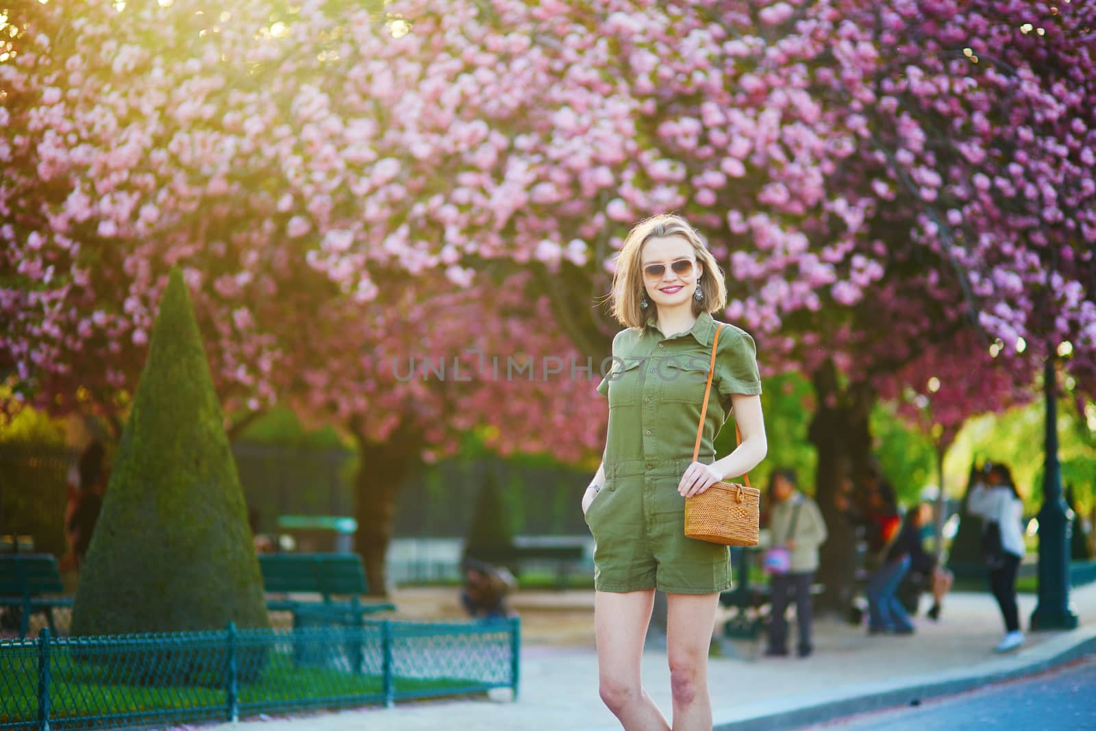 Beautiful French woman walking in Paris on a spring day at cherry blossom season