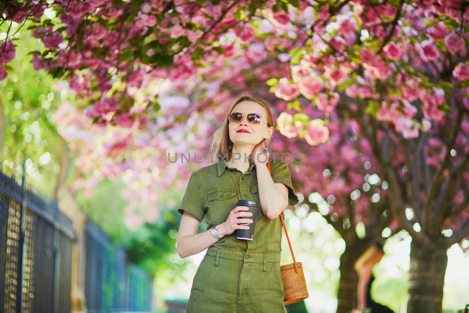 Beautiful French woman walking in Paris on a spring day at cherry blossom season