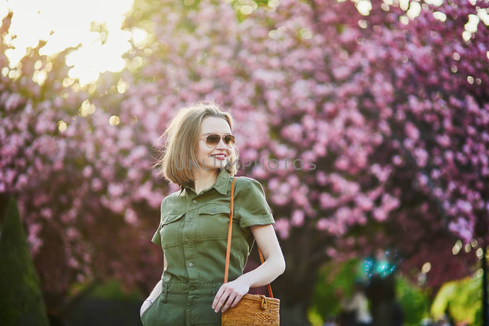 Beautiful French woman walking in Paris on a spring day at cherry blossom season