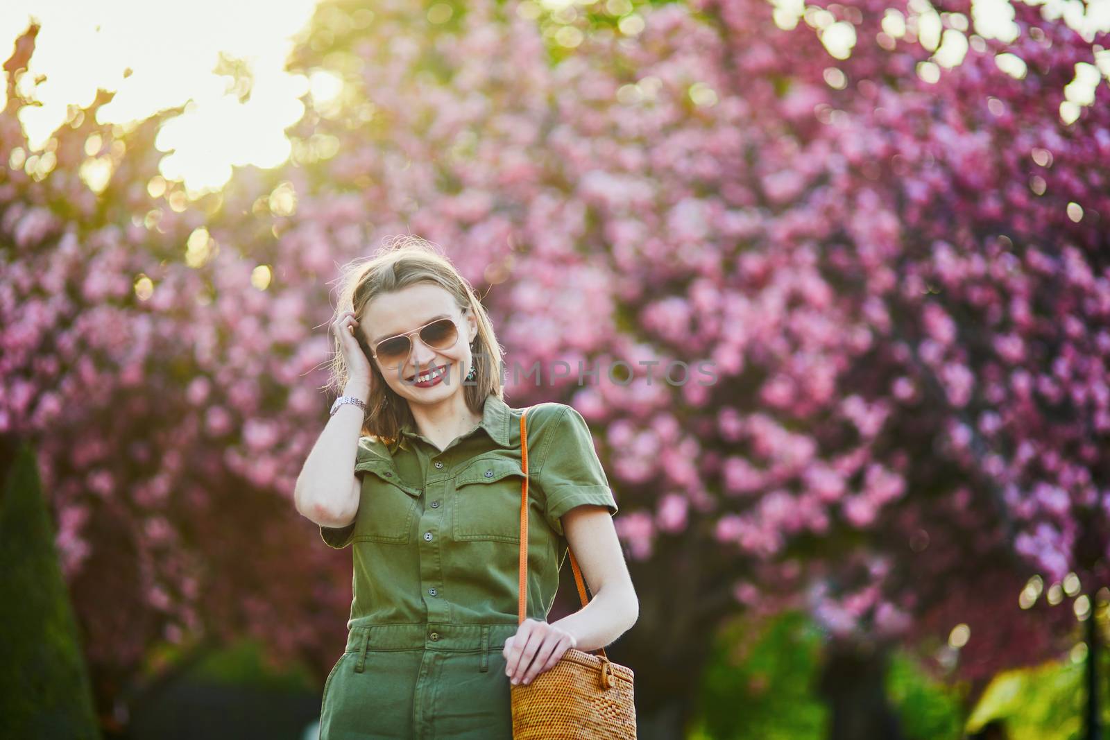 Beautiful French woman walking in Paris on a spring day at cherry blossom season